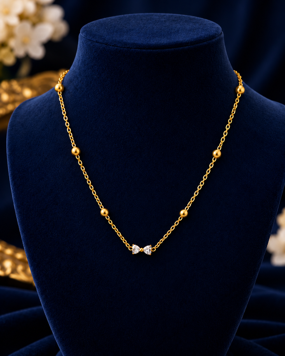 Gold-Tone Crystal Bow Necklace on navy velvet display