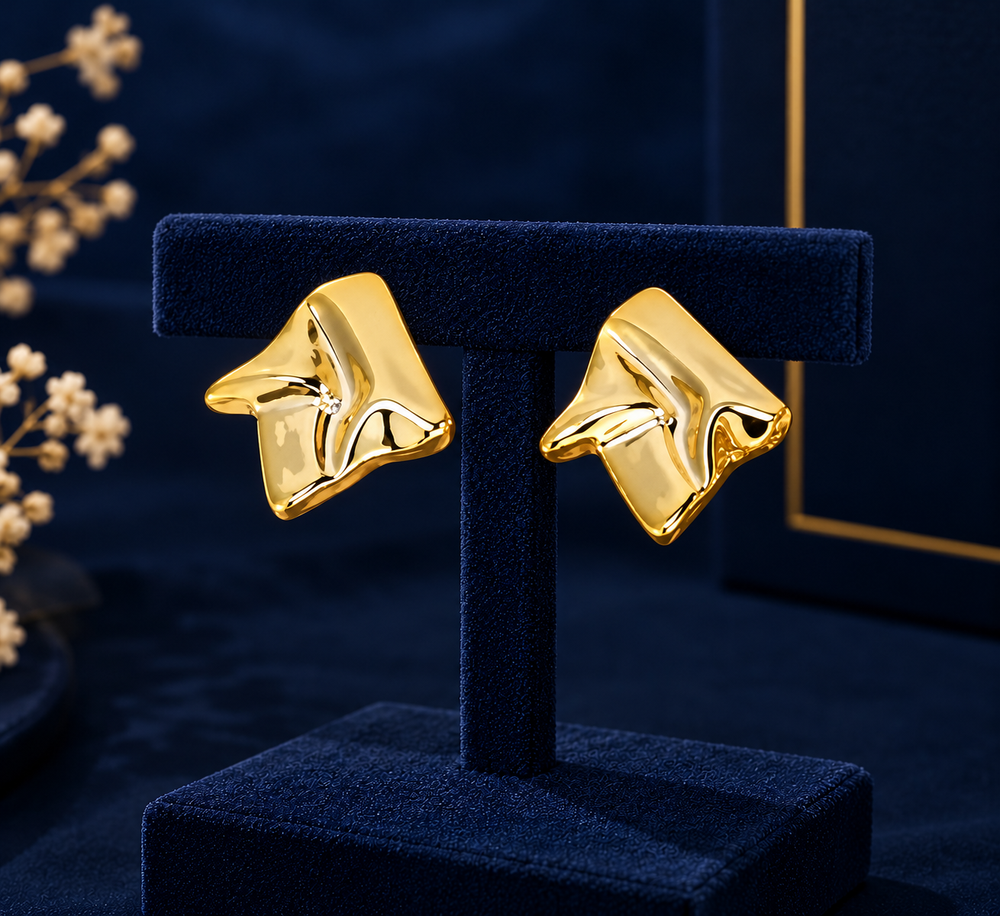 Gold-Tone Sculpted Fold Stud Earrings on navy velvet display