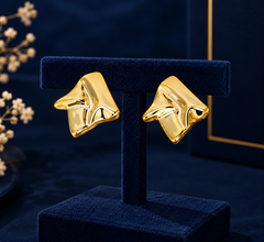 Gold-Tone Sculpted Fold Stud Earrings on navy velvet display