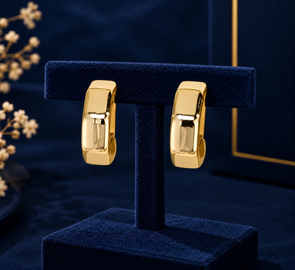 Gold-Tone Faceted Flat Huggie Earrings on navy velvet display