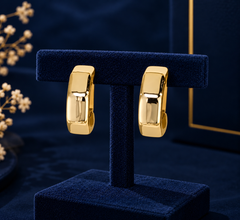 Gold-Tone Faceted Flat Huggie Earrings on navy velvet display