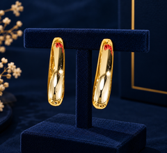 Gold-Tone Elongated Oval Hoop Earrings on navy velvet display