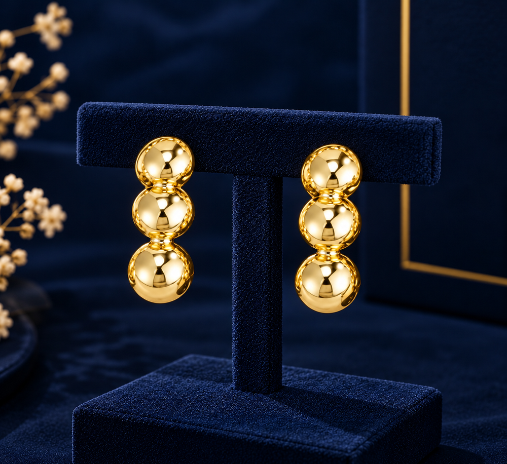 Gold-Tone Triple Bead Drop Earrings on navy velvet display