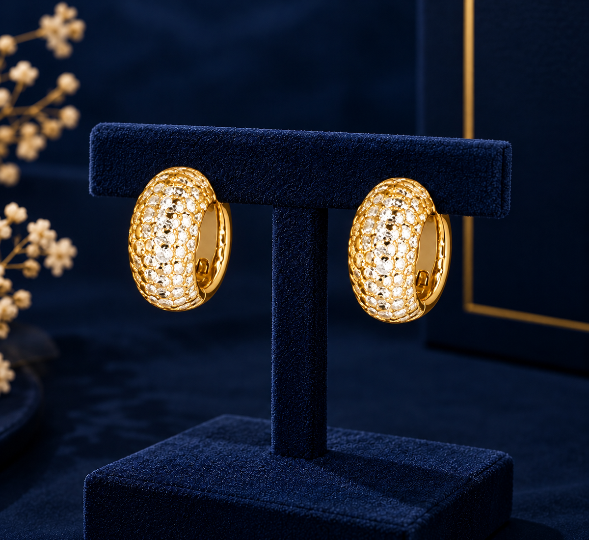 Gold-Tone Crystal Pave Huggie Earrings on navy velvet display