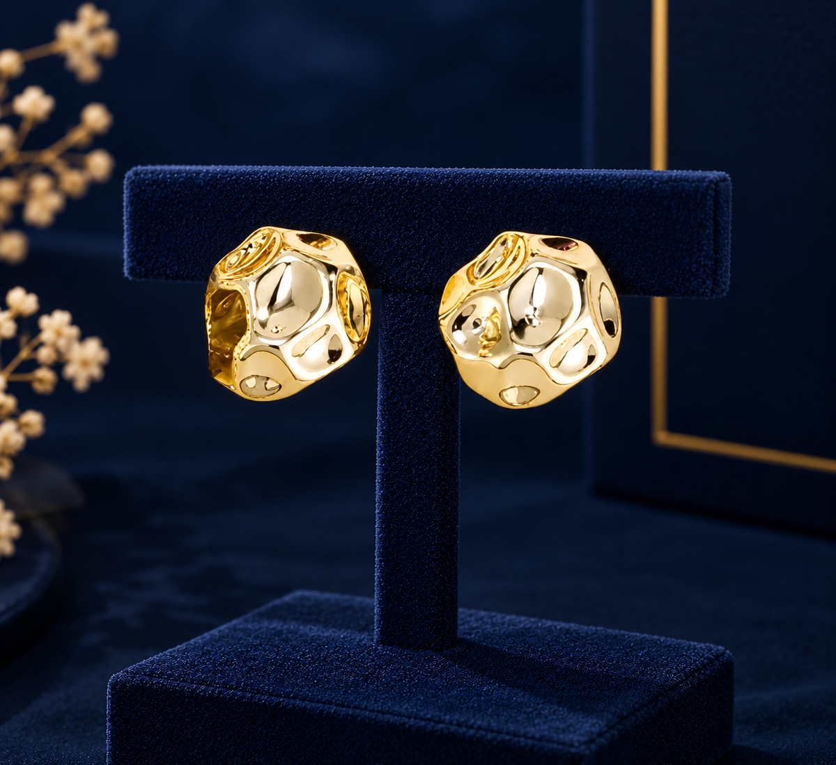 Gold-Tone Openwork Oval Huggie Earrings on navy velvet display