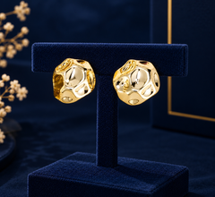 Gold-Tone Openwork Oval Huggie Earrings on navy velvet display